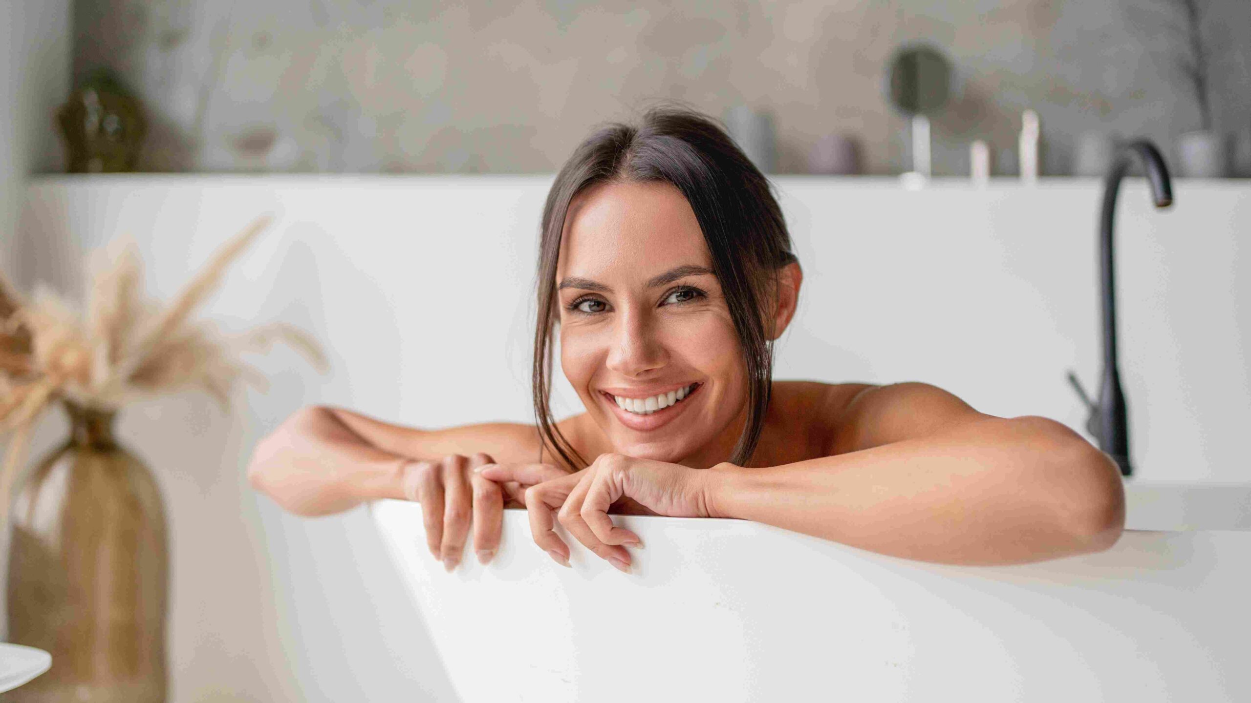 Žena se opušta u kadi i smeši se